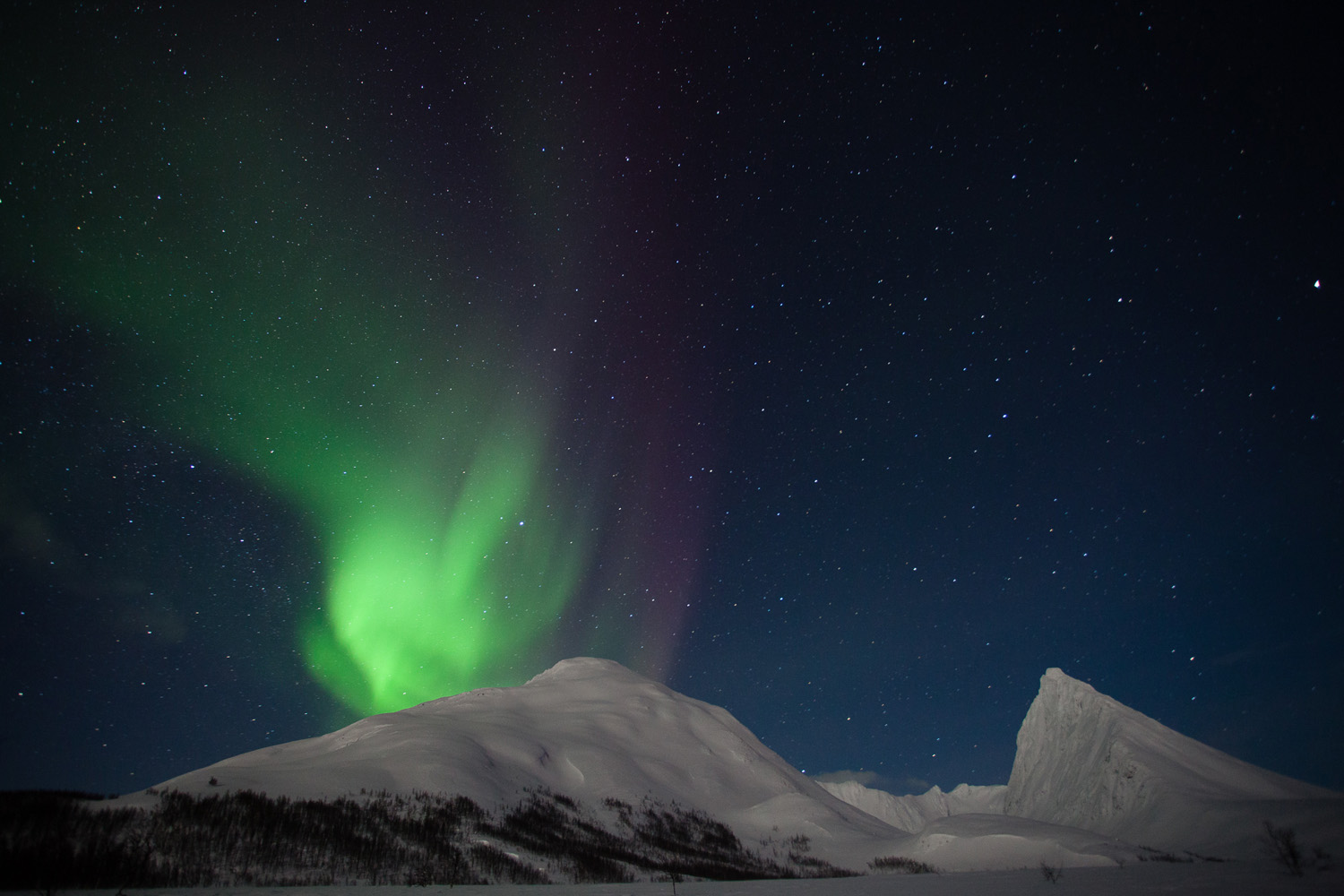 photo d'aurores boréales sur le Middagtinden, dans les Alpes de Lyngen, en Norvège.