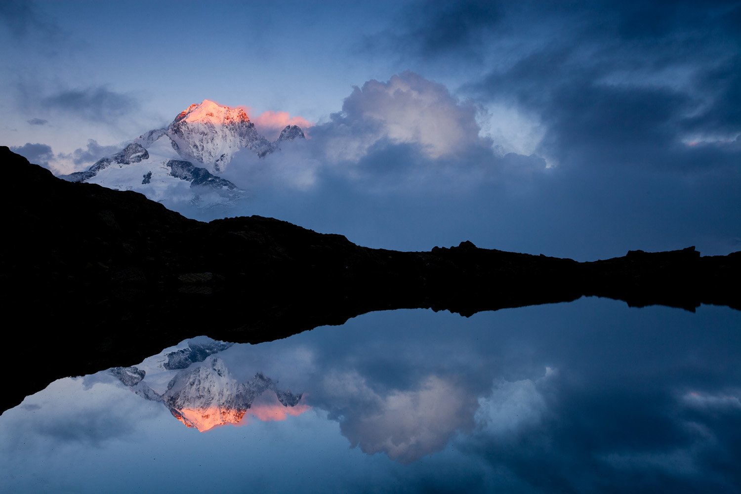 L'aiguille verte sort des nuages et son reflet dans le lac de Chesery, à Chamonix Mont Blanc