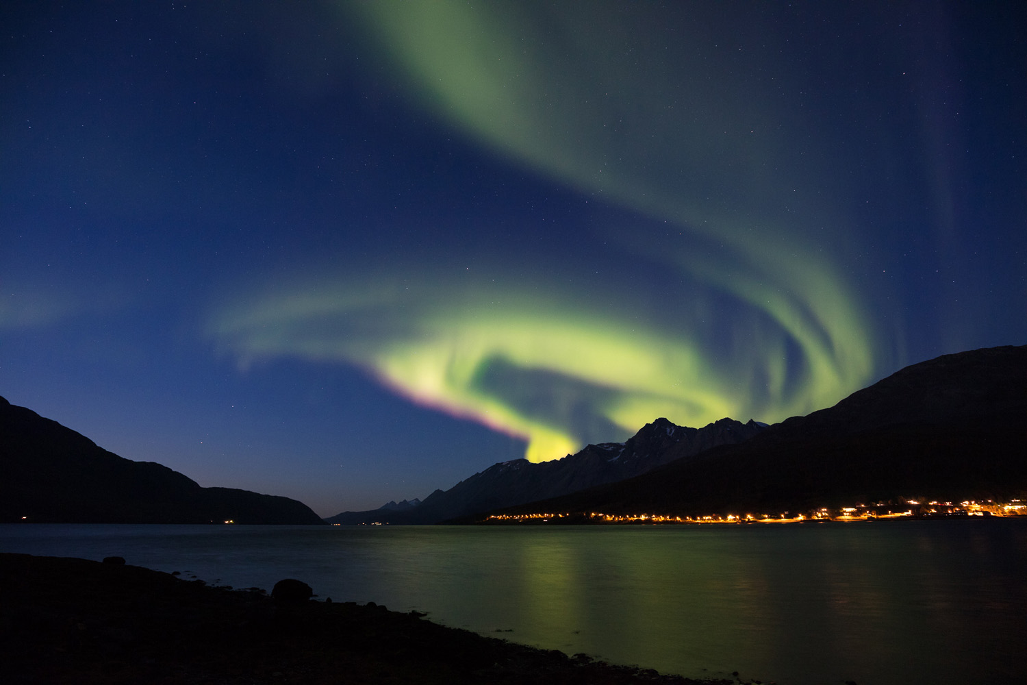aurore boréale en spirale sur les Alpes de Lyngen, à Lakselvbukta, peandnt un voyage photo à Tromsø en Norvège